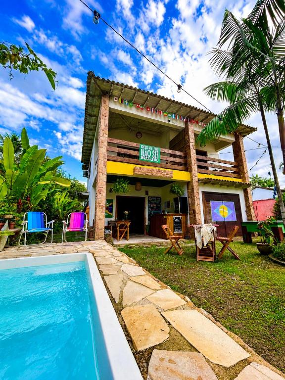a house with a swimming pool in front of it at Hostel Mawe in Paraty