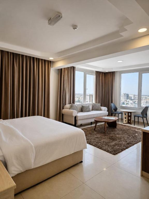 a hotel room with a bed and a couch at Diamond Star Hotel فندق النجمة الماسية in Seeb