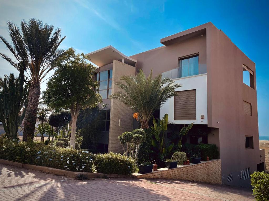 a house with palm trees in front of it at YMY Beach House in Agadir