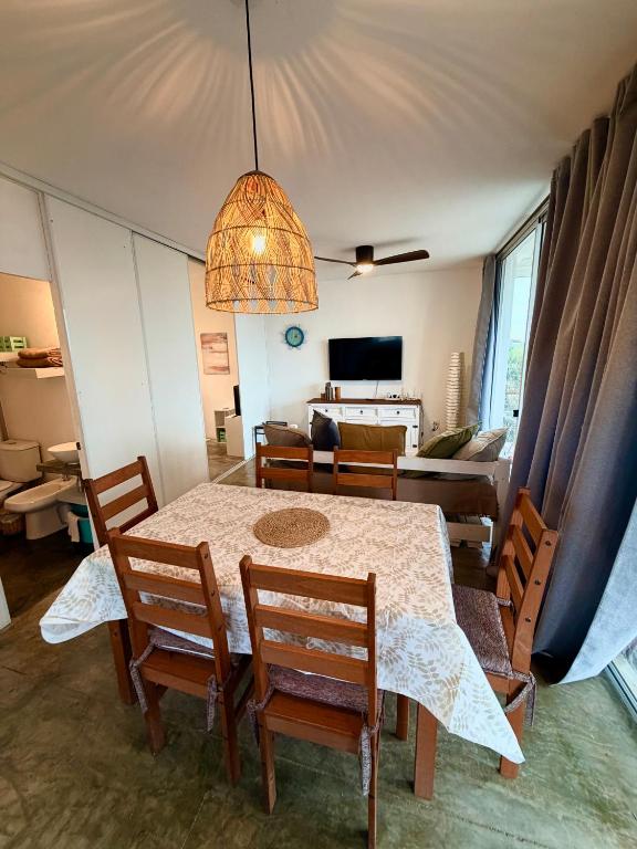 a dining room with a table and chairs and a living room at Acacias PDD in Punta Del Diablo
