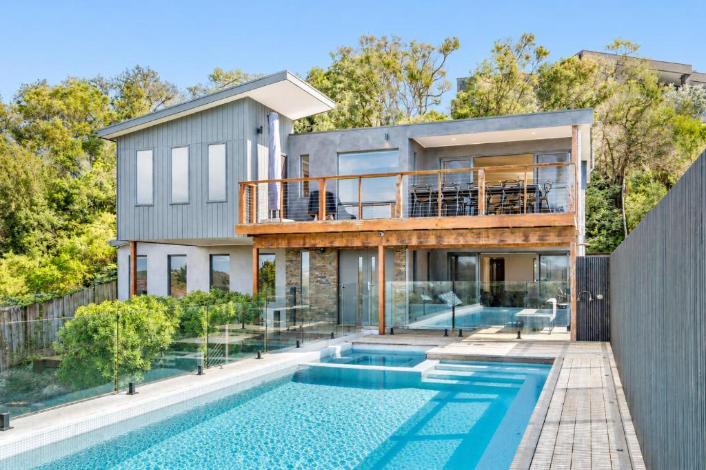 a home with a swimming pool and a house at Nautilus by Ready Set Stay in Rye