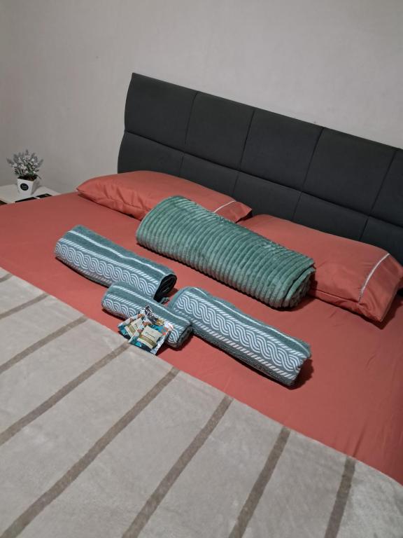 two pillows on a bed with a couch at Flat luxo e tranquilidade in Volta Redonda
