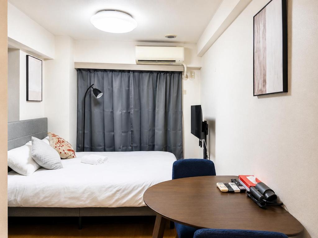 a hotel room with a bed and a table and a table at Ichigaya Stay & Wi-Fi 1 in Tokyo