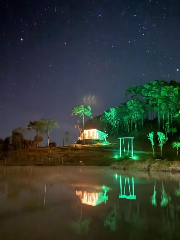 a night view of a house with green lights at CABANA AURORA com passeios a cavalo gratuito in Urubici