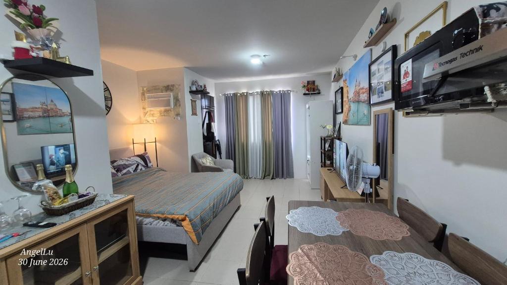 a bedroom with a bed and a living room at Comfy WalkUp Studio Near Mactan Airport -Perfect for Travellers in Lapu Lapu City