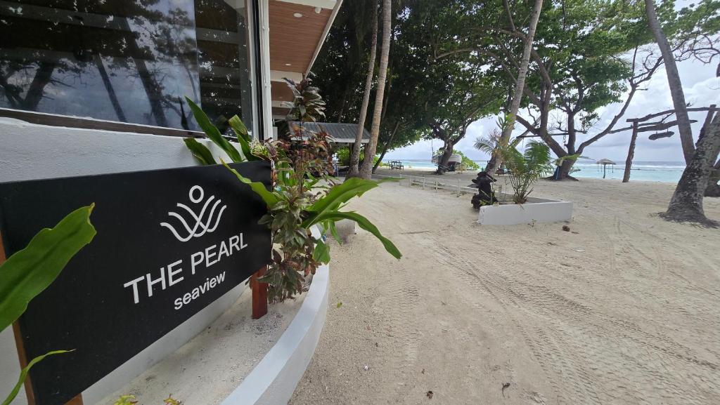 a sign on the beach next to a building at The Pearl Seaview in Fulidhoo