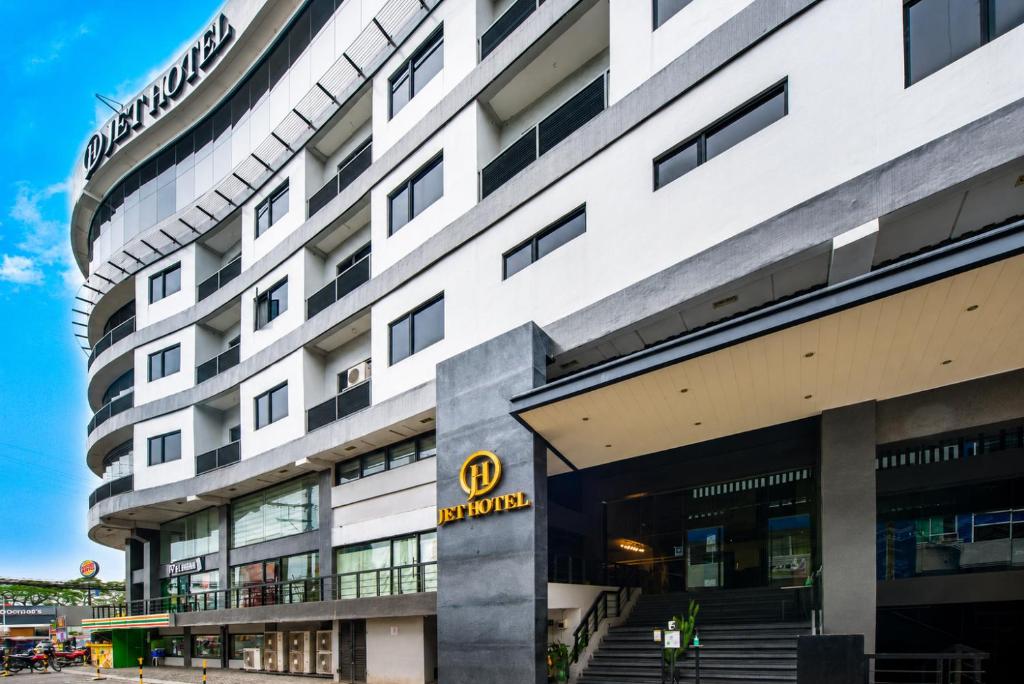 a large white building with a sign on it at JET Hotel Lipa City in Lipa