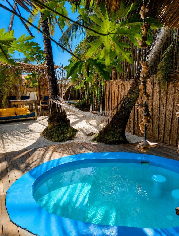 a small blue pool in a yard with palm trees at Karibuni Marafiki in Bwejuu