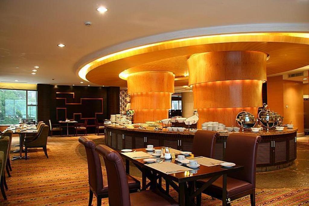 寧波市にあるニンボー ポートマン プラザ ホテルのテーブルと椅子のあるレストラン、バー
