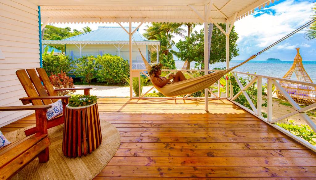 a woman is sitting in a hammock on a porch at Opoa Beach Hotel in Opoa