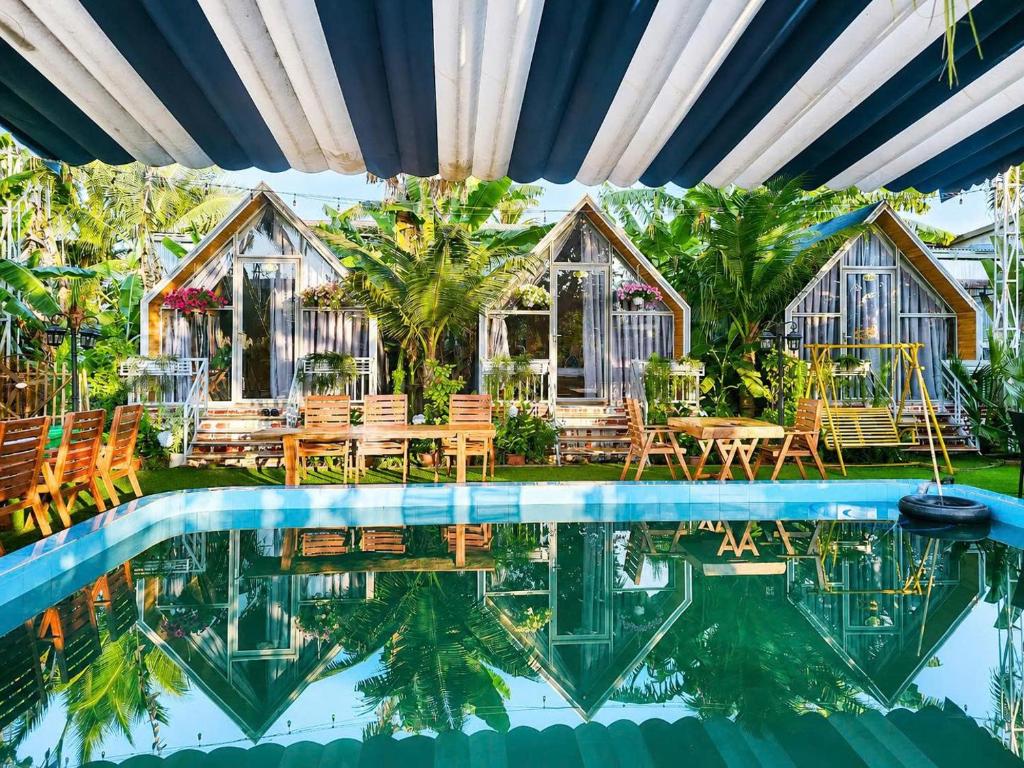 a resort with a swimming pool and a house at Dak Nguyen Homestay DakLak in Buon Ma Thuot