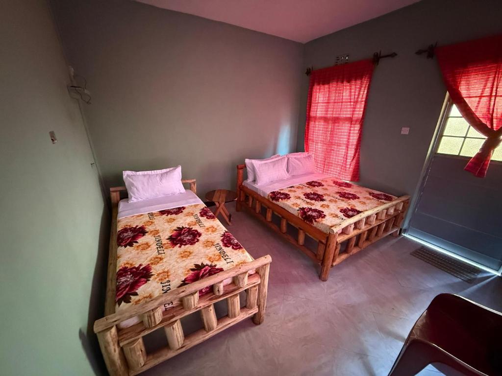 a bedroom with two beds and a window at Oltare Safari Homestay in Makuyuni