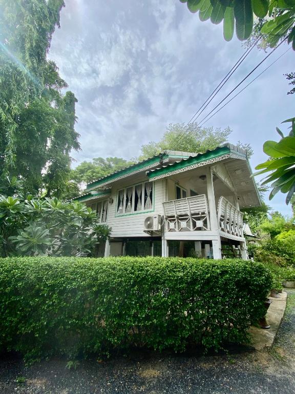 a white house with a bush in front of it at Baan Suan Yensabai @Ayutthaya in Phra Nakhon Si Ayutthaya