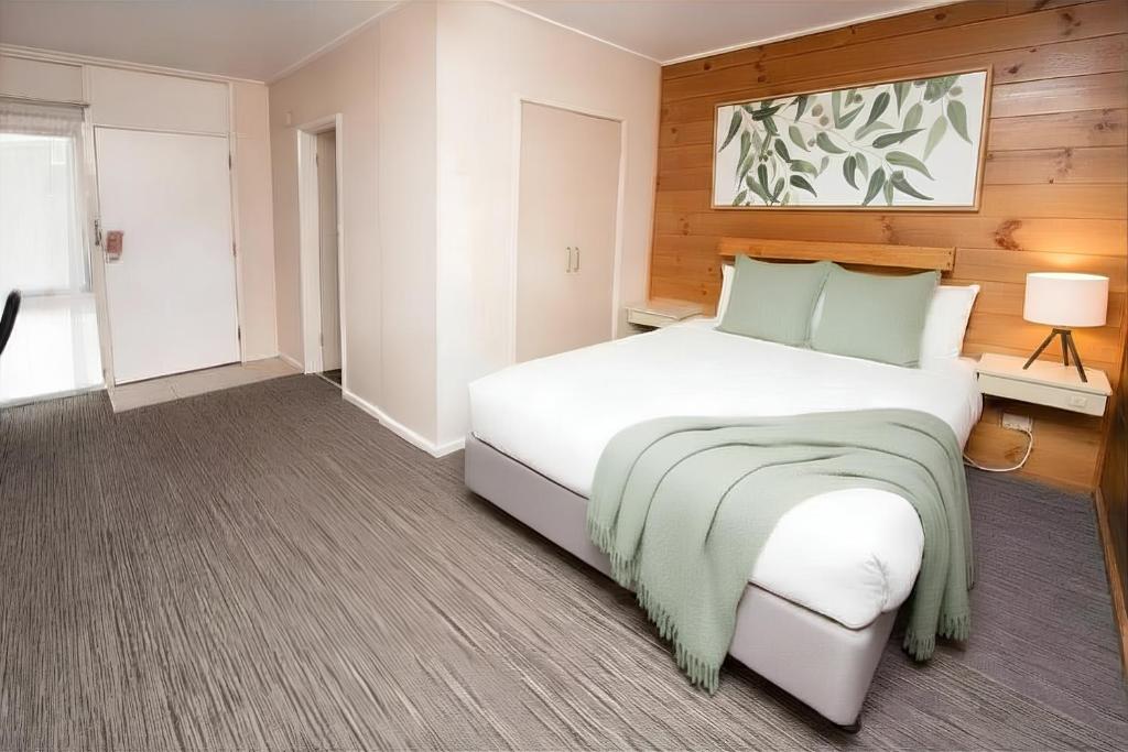 a bedroom with a large white bed in a room at Paruna Motel in Swan Hill