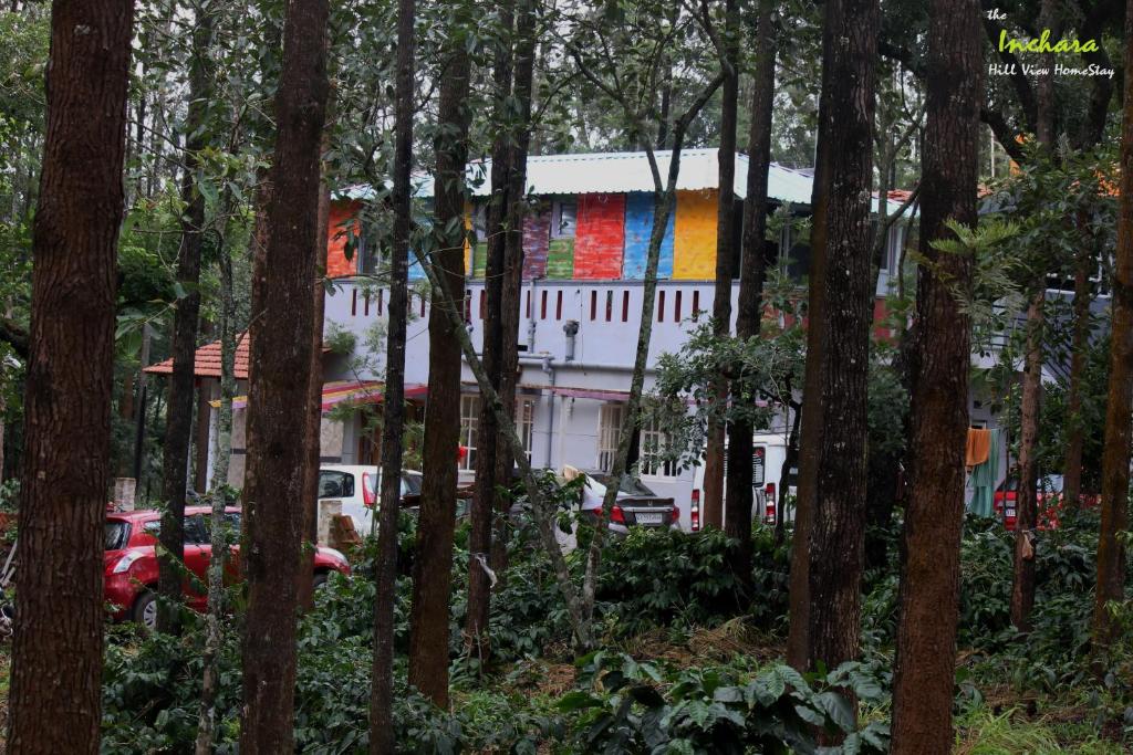 a building with a painting on the side of it in the woods at The Inchara Hill View HomeStay in Chikmagalūr