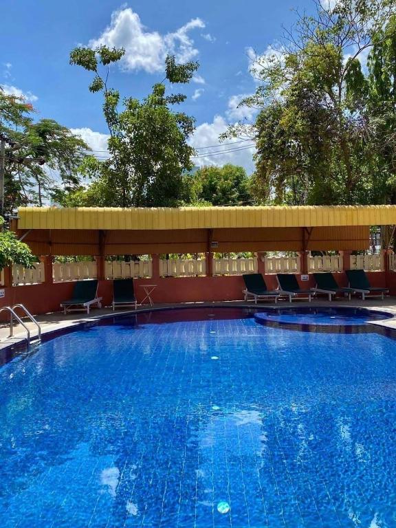 a large swimming pool with chairs around it at Takiab Beach Resort in Hua Hin