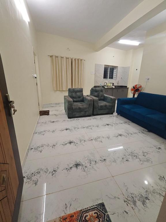 a living room with a couch and a blue couch at Kalpavrukksha Luxury Service Apartment- Unit 4 - 1 BHK 2 King Size Cot Setup in Chikmagalūr