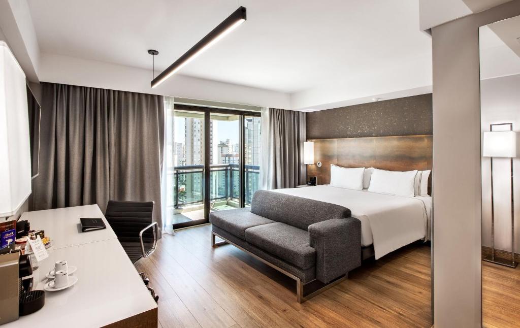 a hotel room with a bed and a desk at Meliá Ibirapuera in São Paulo