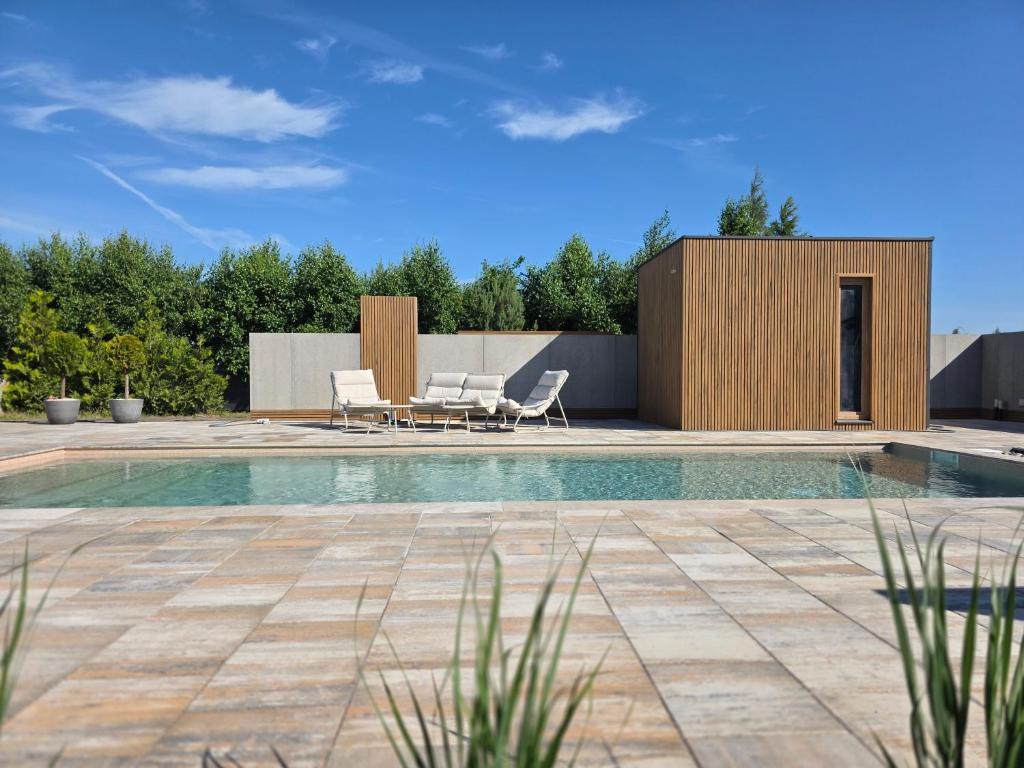a swimming pool in a backyard with a house at Apartamenty Nadmorska Osada in Łeba