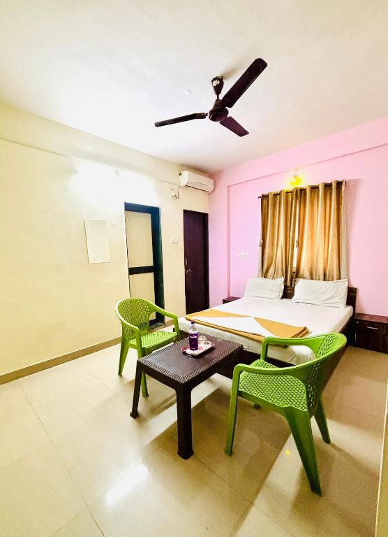 a room with a bed and a table and chairs at Hotel Laxmi in Hinjewadi