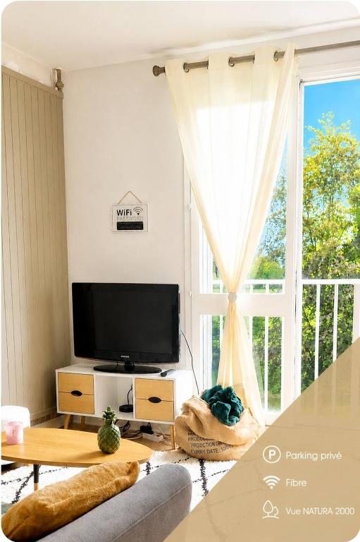 a living room with a tv and a large window at Natura2000 in Châteauroux