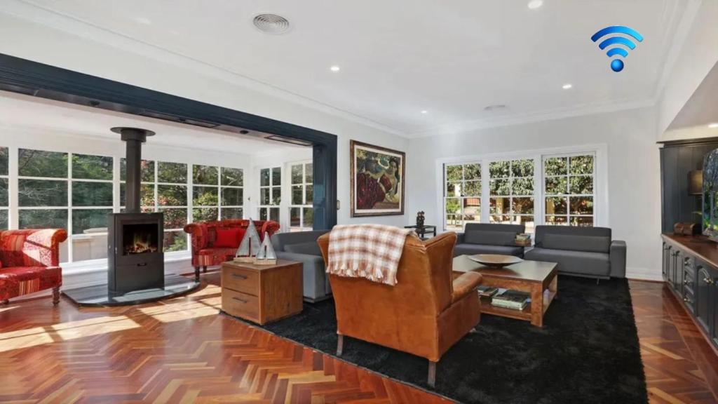 a living room with a couch and a fireplace at Southern Grace in Bowral
