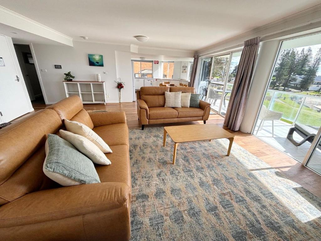 a living room with a couch and a table at Ocean Shores Apartment 14 - Bring your own linen. in South West Rocks