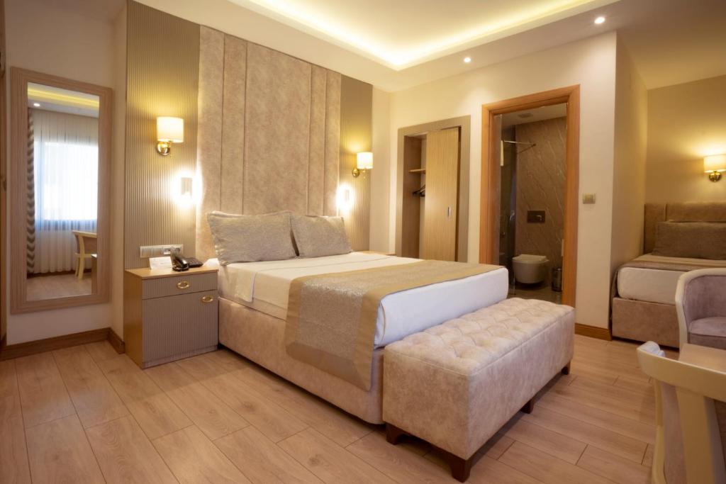 a bedroom with a bed and a chair in a room at Othello Hotel in Mersin