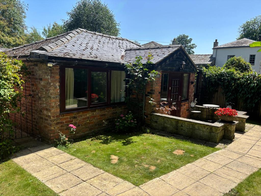 a small brick house with a window and a yard at Claire Cottage in Selby