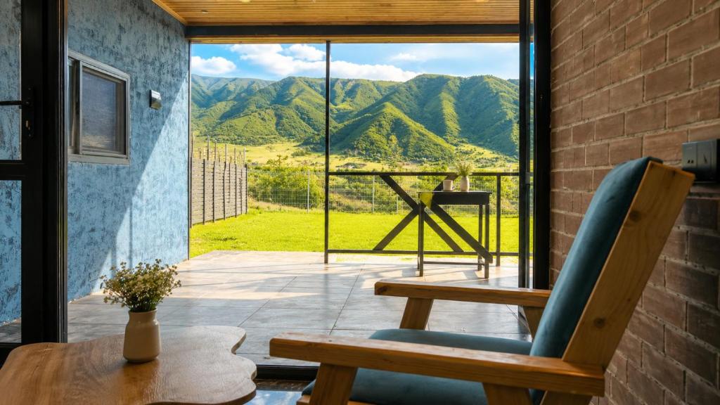 a room with a table and a chair and a window at Shahdag Berghoff Villas in Qusar