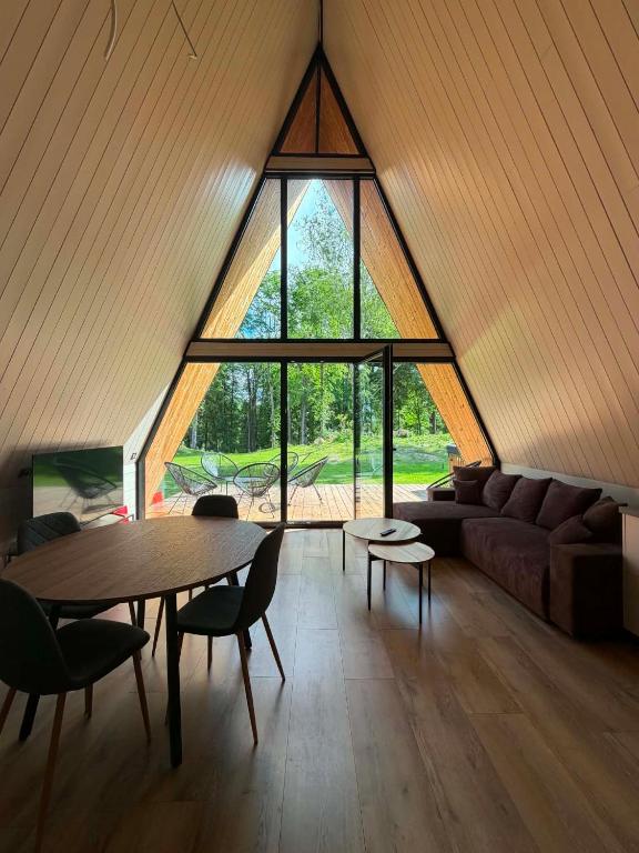 a living room with a table and a large window at Frame Village in Žaugėdai