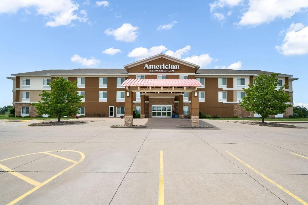 an apartment building with a parking lot in front of it at AmericInn by Wyndham Fairfield in Fairfield