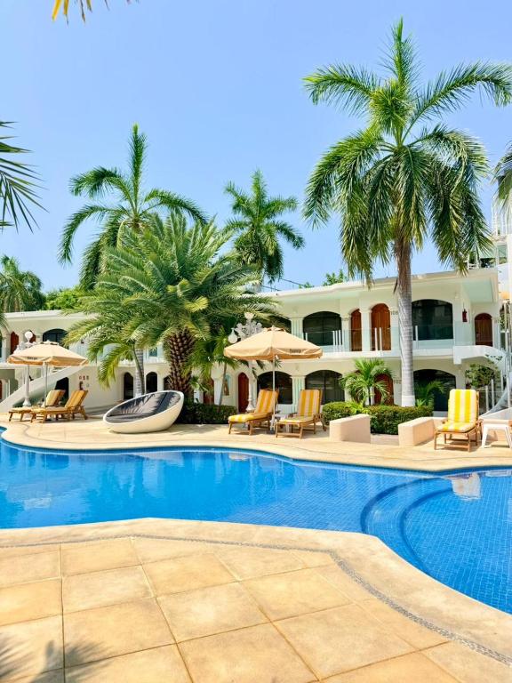 ein Resort-Schwimmbad mit Liegestühlen und Sonnenschirmen in der Unterkunft Hotel Costa Azul in Acapulco