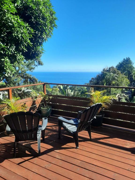 two chairs on a deck with the ocean in the background at Fare TANGARA in Arue