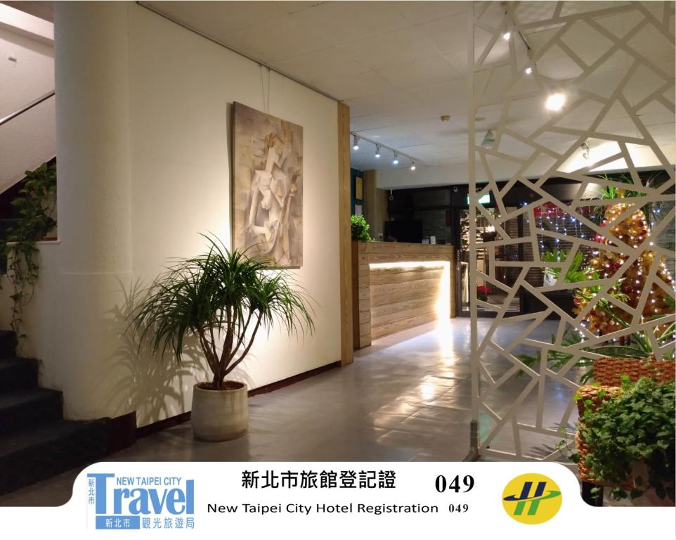 a lobby with a potted plant on a wall at Yi Yuan Hotel in Taipei