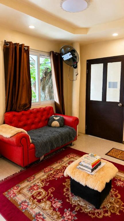 a living room with a red couch and a window at Casa De Oro in El Nido