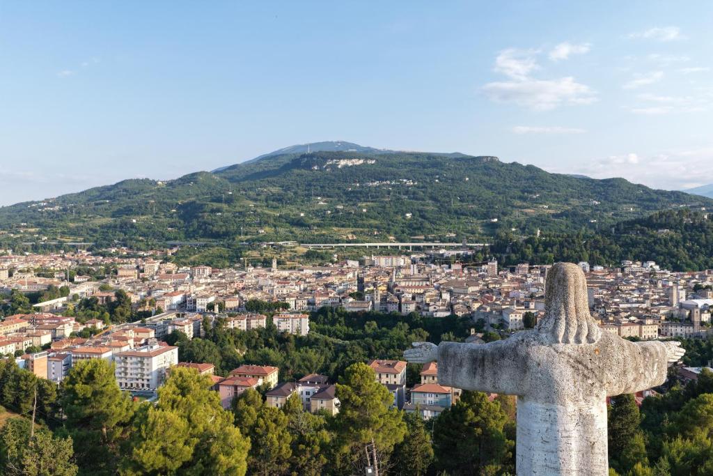 a statue of a cross overlooking a city at Rifugio collina del Sacro Cuore in Ascoli Piceno
