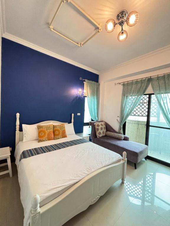 a bedroom with a bed and a blue wall at 花蓮觀月民宿-近車站-寵物友善-含車位可包棟8-14位 烤肉麻將僅提供給包棟使用 in Hualien City