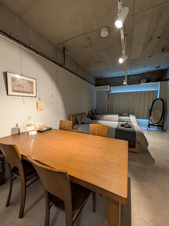 a room with a wooden table and a bed at ギャラリーのある宿canvas in Nagoya