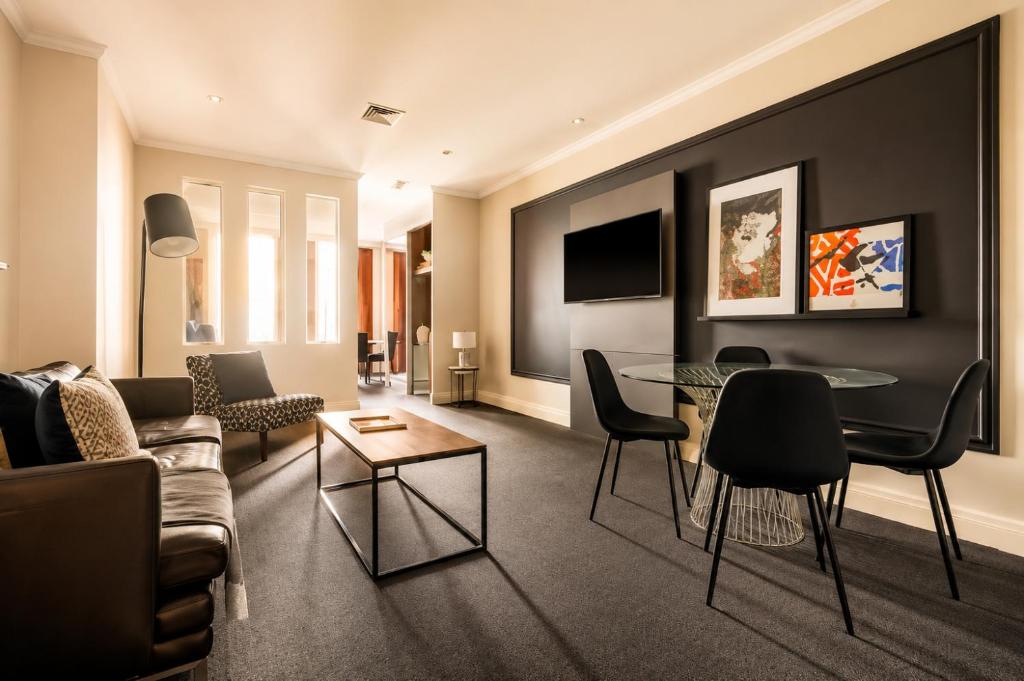 a living room with a couch and a table at Stylish CBD 1BR - Gym & Lounge - Next to Chinatown in Melbourne