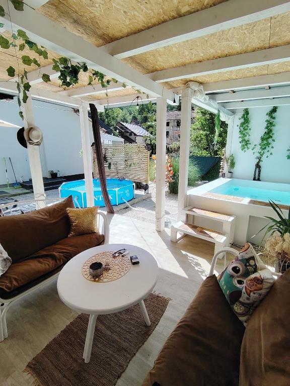 a living room with a couch and a table and a swimming pool at Kuća za odmor MERLIN HOUSE in Vrnjačka Banja