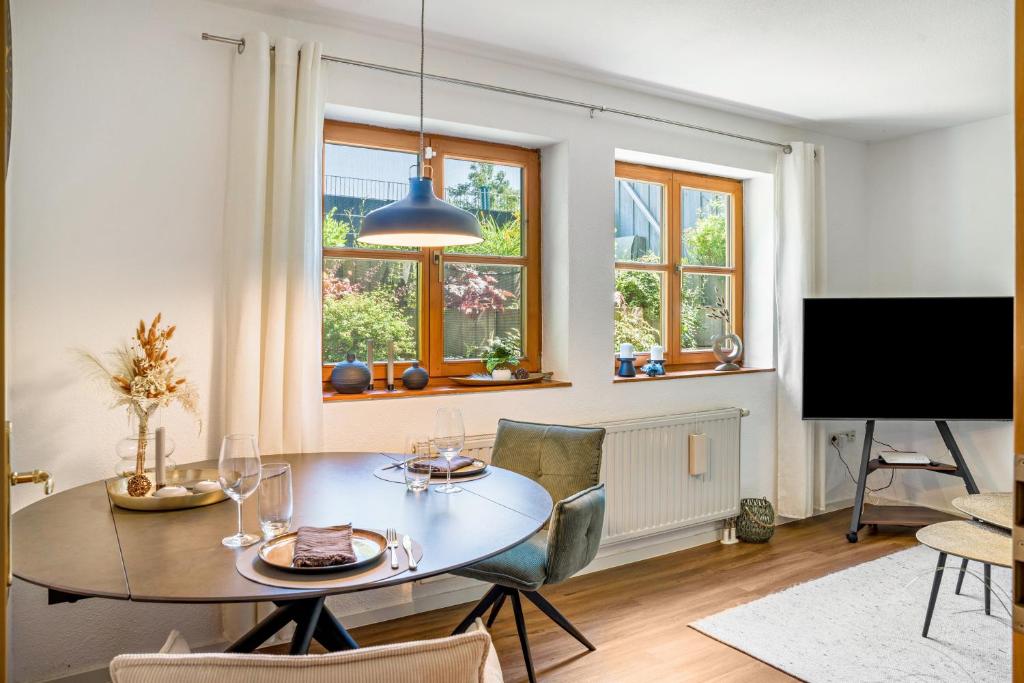 a dining room with a table and chairs and a tv at Fewo Stembers in Heideck