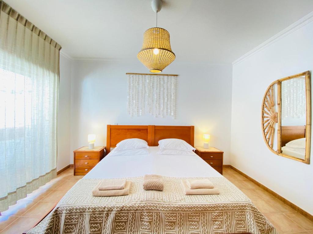 a bedroom with a large bed and a mirror at Aloha Burgau Guesthouse in Burgau