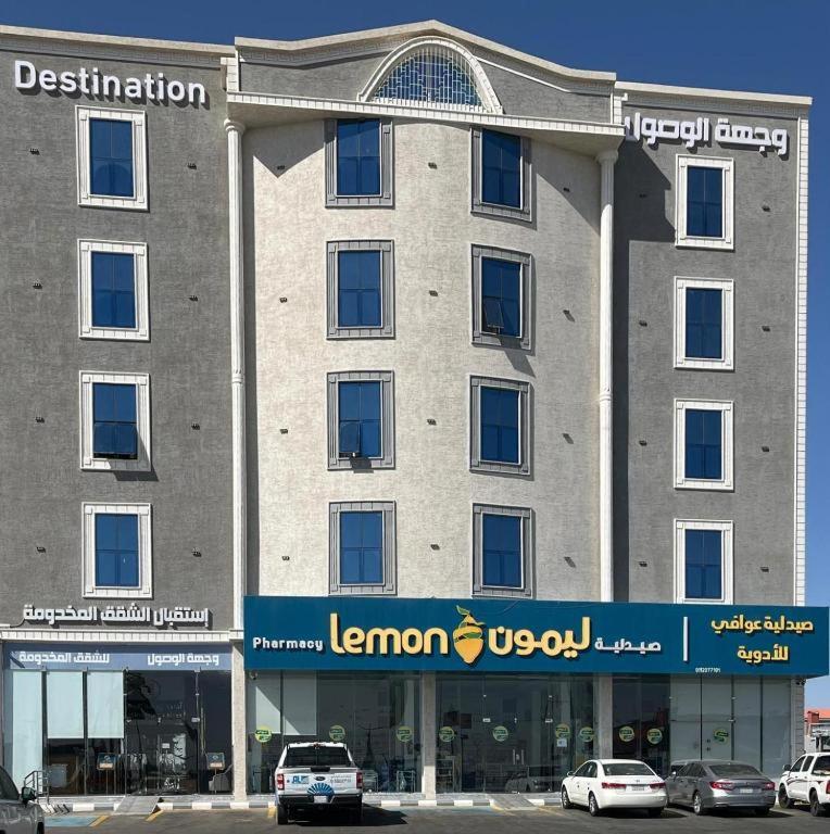 a large building with cars parked in front of it at شقق وجهة الوصول in Ar Rawshān