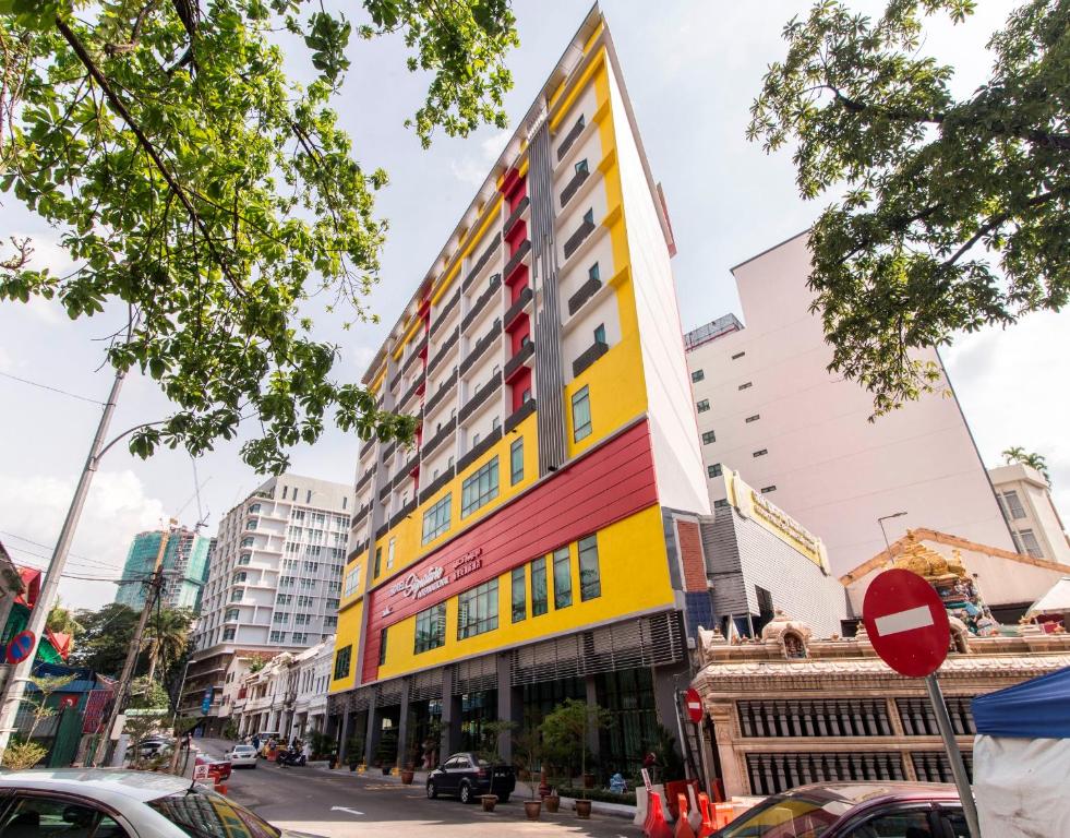 a colorful building on a city street with cars at Signature International Hotel China Town in Kuala Lumpur