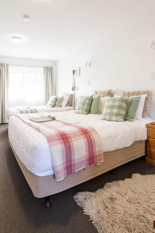 a large bed with a blanket on it in a bedroom at #2 Glenorchy Alpine Suite in Glenorchy