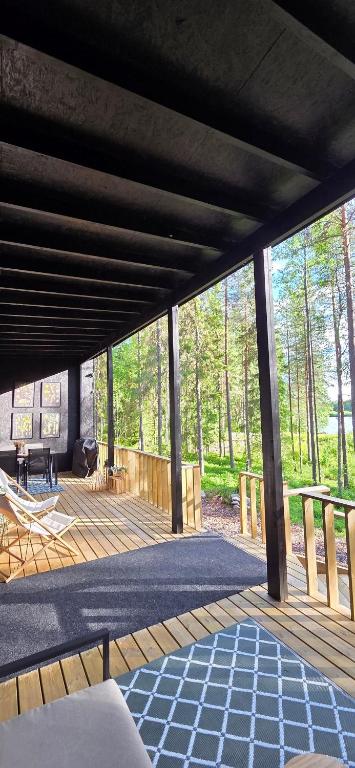 a wooden deck with a view of the woods at Ternu Forestvilla in Rovaniemi