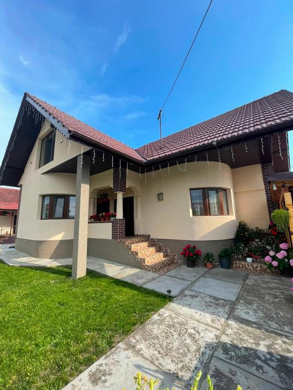 a white house with a red roof at Pensiunea CAV in Novaci-Străini
