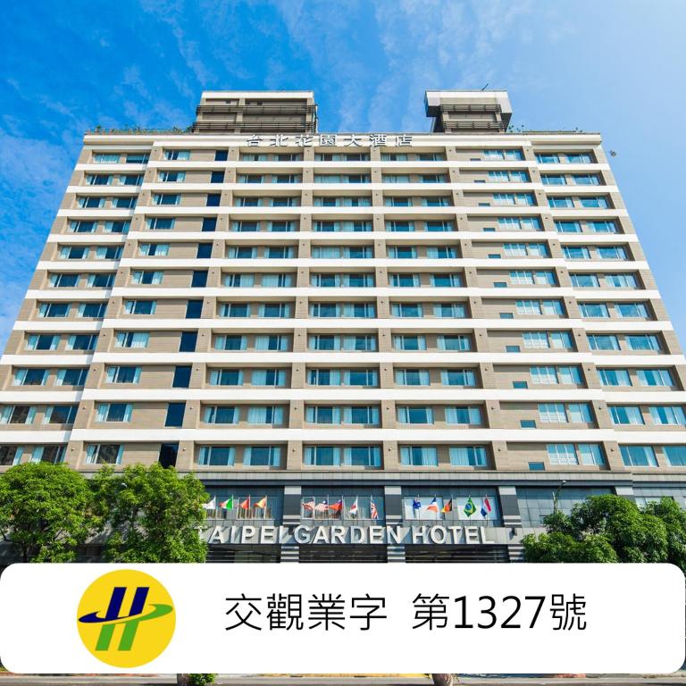 a large white building with a sign in front of it at Taipei Garden Hotel - Ximending in Taipei