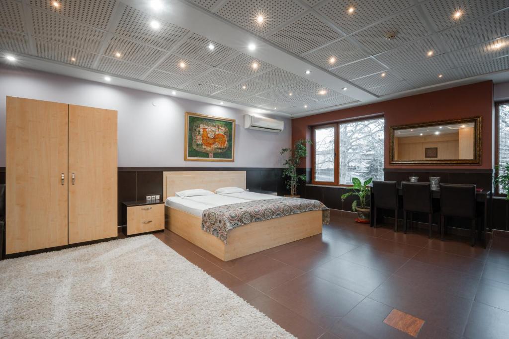 a bedroom with a bed in a room with chairs at Hotel Ego - Parking Available - Top Central Location in Plovdiv
